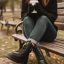 نیم بوت زنانه مشکی در پای یک خانم نشسته